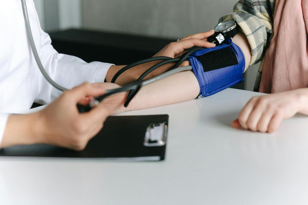 A stethoscope resting on a medical chart with a heart diagram.